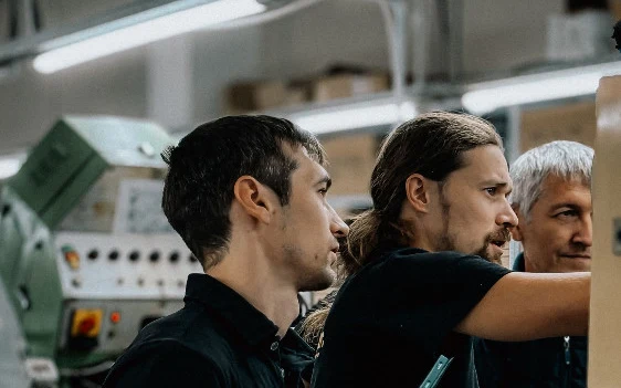 Manufacturing engineers working together beside industrial equipment