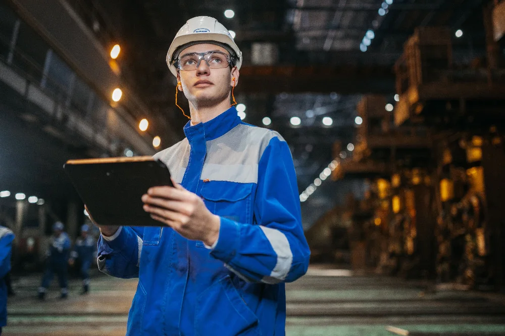 Manufacturing engineer using a tablet in an industrial facility